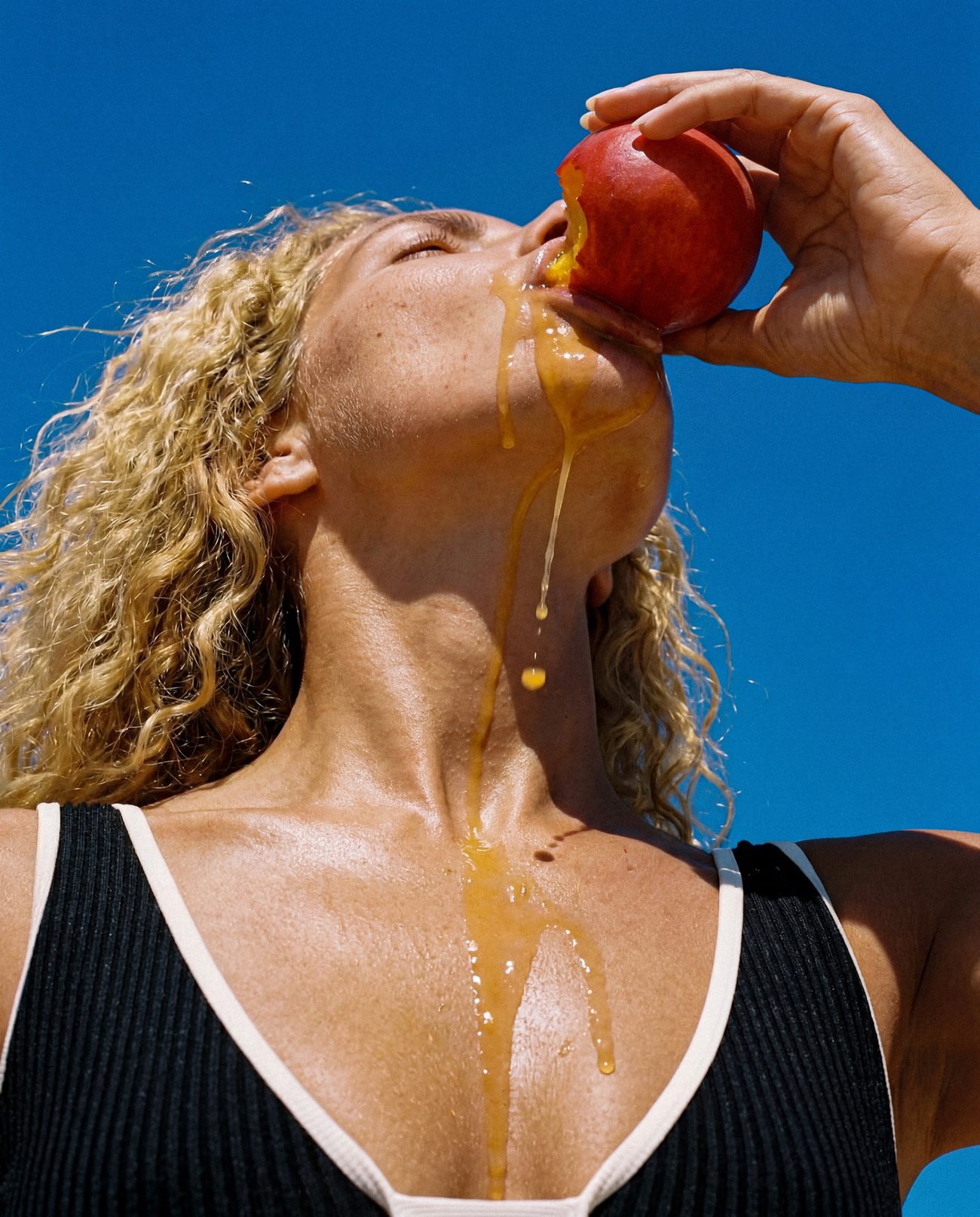 Le jus d'une nectarine coule sur la peau, ciel cobalt